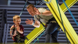 a man and a little boy standing on a climbing structure