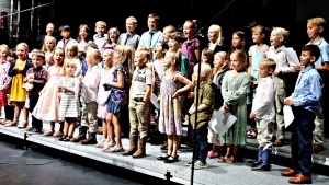 a large children's choir standing on a stage