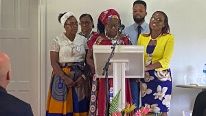 a group of five people standing at a lectern to sing