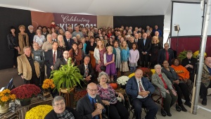 a large group of people standing on a stage or seated in front of it