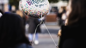 A person hold a balloon that says "Happy Birthday to you"