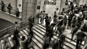 Lots of people going up and down steps in a building - looking busy.