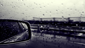 Car side mirror raining outside.