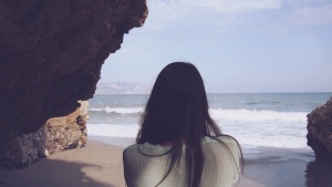 A woman looking at the ocean.