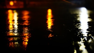 City lights reflecting on a rain covered street.