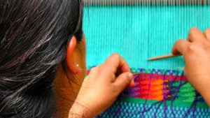 A woman weaving on a loom.