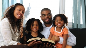 A young family reading Bible to children.