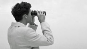 A man looking through binoculars.