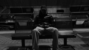 A person sitting along on a bench.