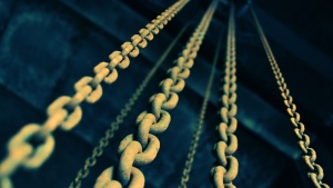 Old chains hanging down from a dark ceiling.