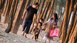 A family walking together on the beach.