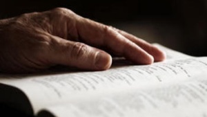 Hand on top of a Bible