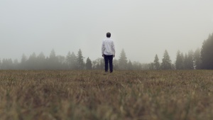 A man standing by himself in an open field.