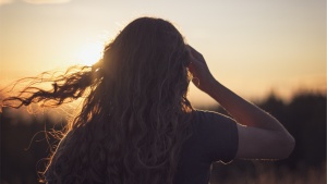 A young woman with her hair blowing in the wind.