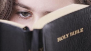 A teen girl reading her Bible.