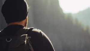 A young man looking over a mountain vista.