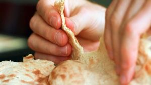 A person pulling apart some flat bread,