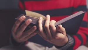 A young man reading a Bible.