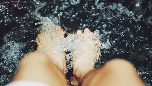 A person&#039;s feet in water.