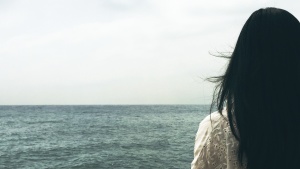 A woman looking at a body of water.