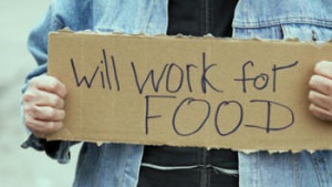 A man holding a "will work for food" sign.