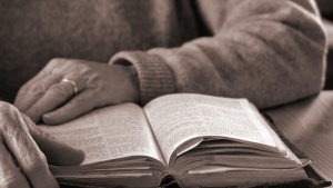 An older person reading a Bible.