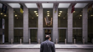 A man across from a big building.