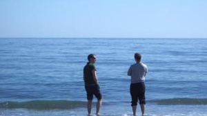 two friends talking as they look at the ocean