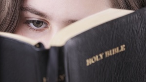 A woman looking at a Bible.