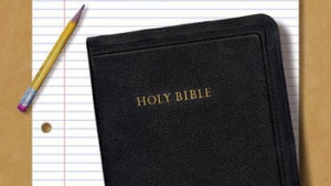 Bible with notepaper and pencil