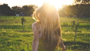 A young woman running in a field.