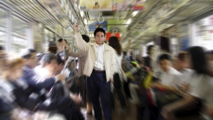 A man surrounded by people on a subway car.