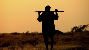 A shepherd carrying a rod.