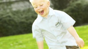 A little boy running on the grass.