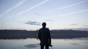 A man looking out over a lake.