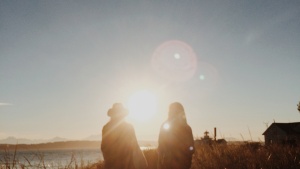 Two women walking toward a beach.