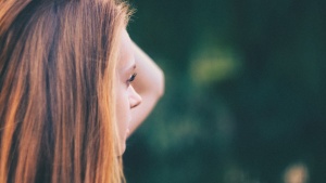 A woman looking with hand her hand by her head.