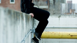 A person sitting on a concrete ledge.