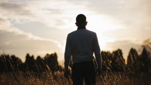 A man looking at the setting sun.