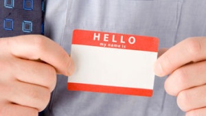 A man holding a Hello..My name is sticker badge.