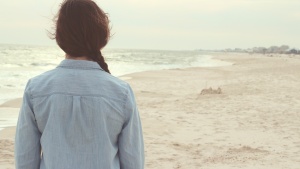 A young woman walking on the beach.