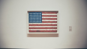 A framed old American flag hanging on a museum wall.