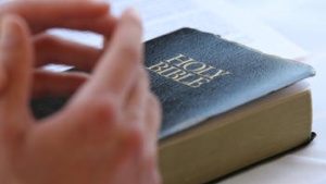 Hand on top of a Bible.