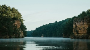 green trees on cliffs above river