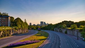 a road running through a village with a cityscape visible on the horizon