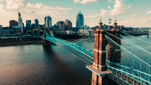 a bridge over a river leading to a city with high-rise buildings