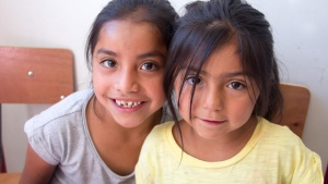 Two girls in school chairs at Eagle's Nest Orphanage