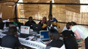 Several people at a table working on laptops in Zambia