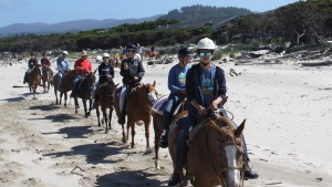 Campers riding horses on the beach at Northwest teen Camp. 