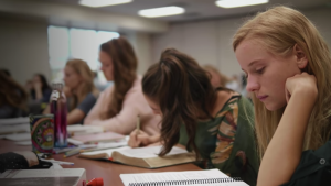 Still from the ABC experience video showing students in class reading their Bibles.